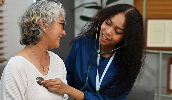 A health care professional listening to a patient's heart sounds using a stethoscope.