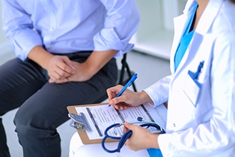 Doctor writing down medical history.