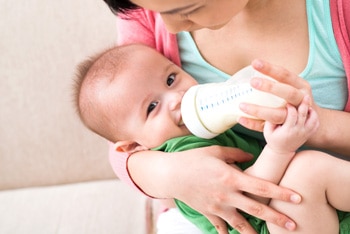 Una madre que alimenta con biberón a su bebé.