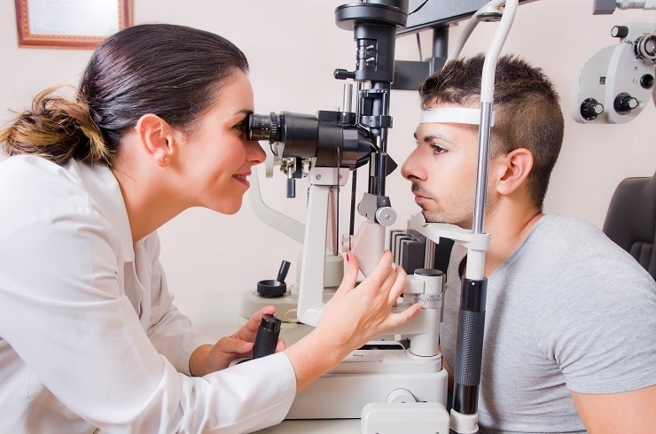 Doctor using a slit lamp to examine a patient’s eyes.
