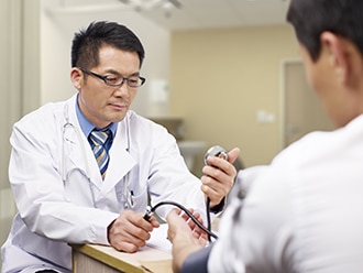 A doctor checking a patient’s blood pressure.