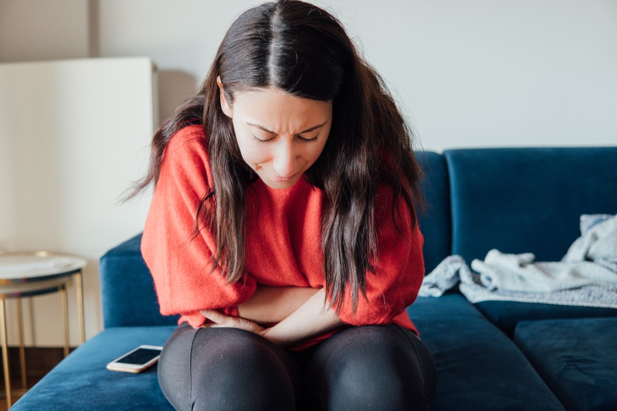 Woman with stomach pain holding her stomach.