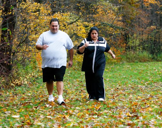 Man and woman powerwalking outdoors.