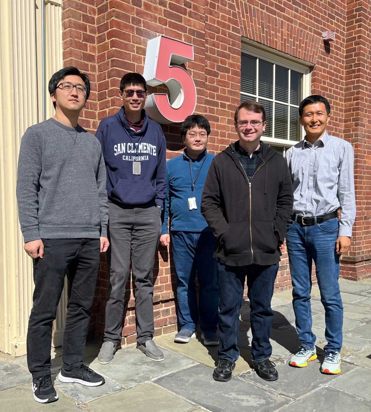 Lab members standing outside and smiling.